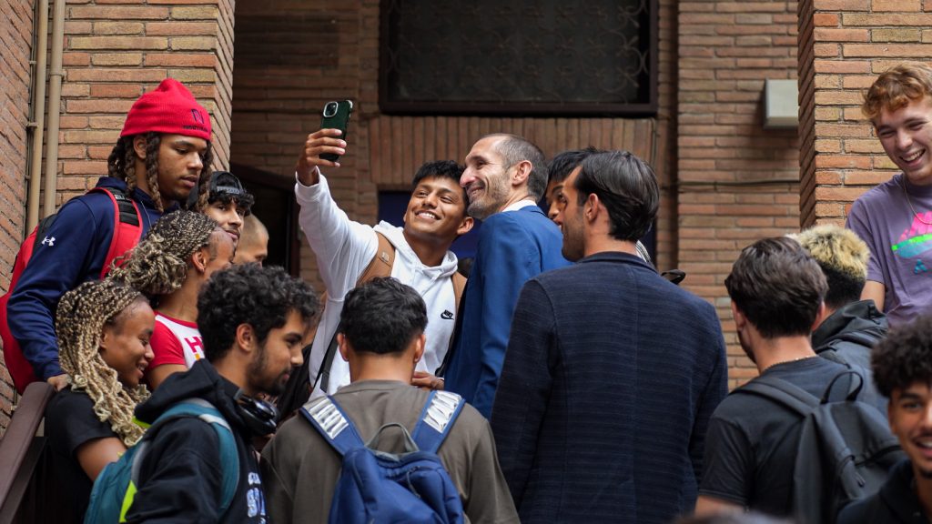 Foto di Giorgio Chiellini che scatta un selfie con un fan, circondato di giovani ragazzi